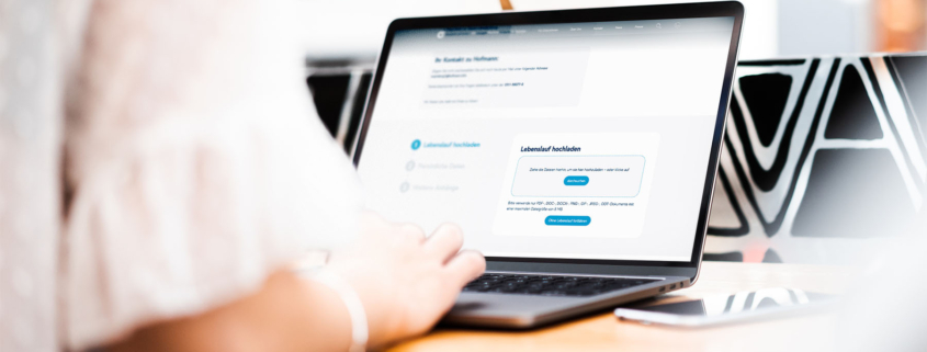 Eine Person schaut sich die geöffnete Website von Hofmann Personal auf einem Laptop an